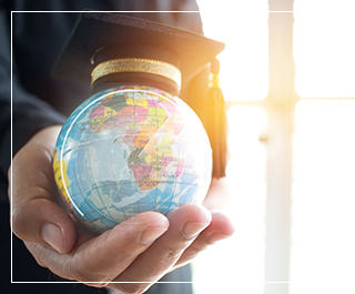 hand holding a globe of earth with a graduation hat